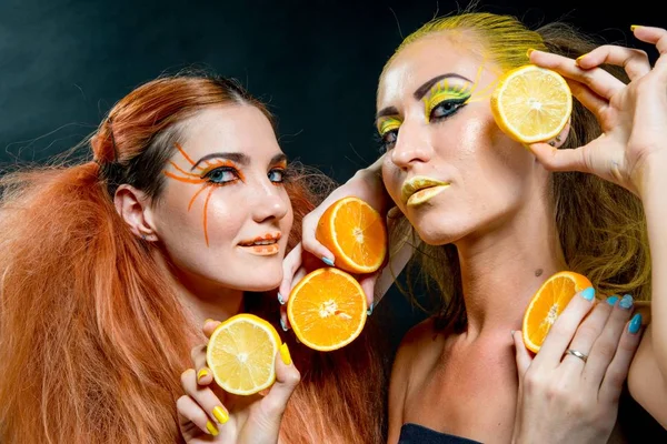 İki genç kız narenciye dilimleri ile