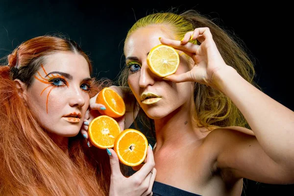 İki genç kız narenciye dilimleri ile