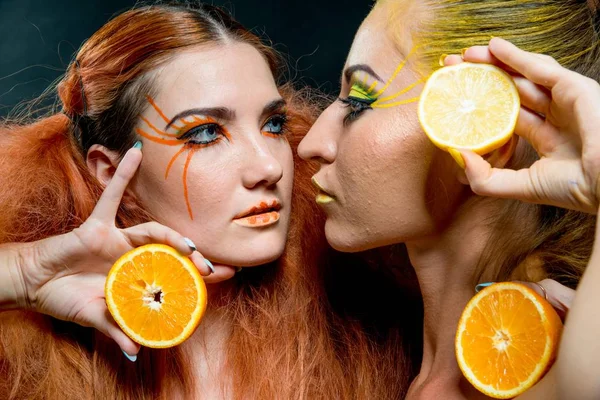 İki genç kız narenciye dilimleri ile