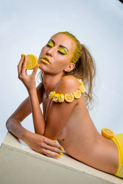 beautiful girl with yellow hair and a slice of lemon