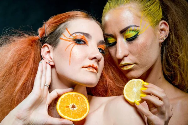 İki genç kız narenciye dilimleri ile