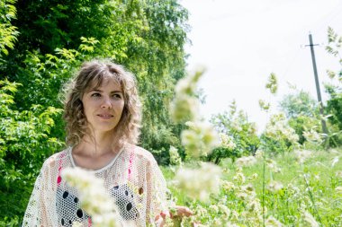 Yeşil çimlerle poz veren güzel bir kadın. 