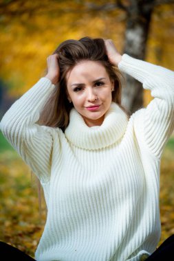 Güz parkında poz veren güzel bir kadın. 