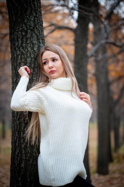 Güz parkında poz veren güzel bir kadın. 