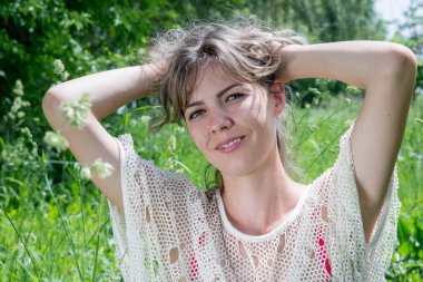 Yeşil çimlerle poz veren güzel bir kadın. 