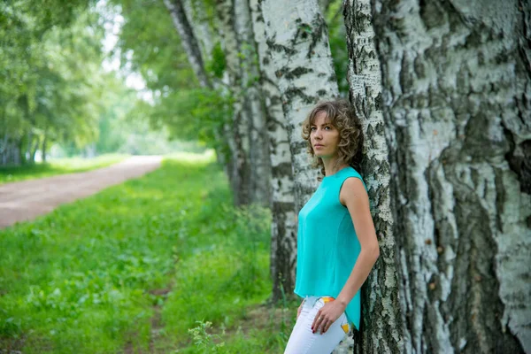 美丽的女人站在白桦树旁 — 图库照片