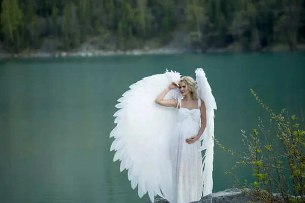 beautiful bride with angel wings posing in nature