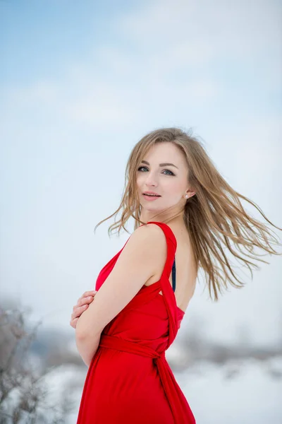 冬には赤いドレスを着た美しい女の子が屋外でポーズ — ストック写真