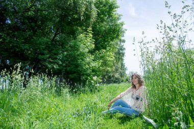 Yeşil çimlerle poz veren güzel bir kadın. 