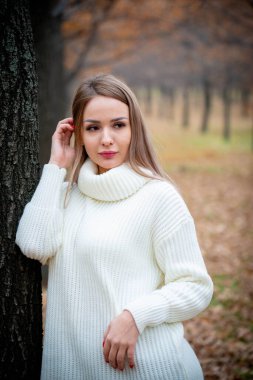 Güz parkında poz veren güzel bir kadın. 