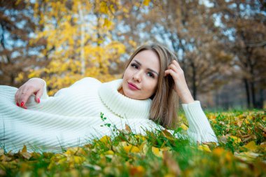 Güz parkında poz veren güzel bir kadın. 