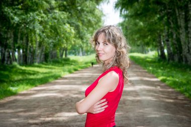 Sokakta huş ağaçlarıyla poz veren güzel bir kadın.