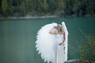 Doğada poz veren melek kanatlı güzel gelin 