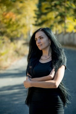 Güzel esmer kadın model dışarıda poz veriyor. 