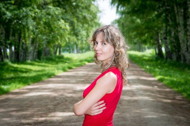 Sokakta huş ağaçlarıyla poz veren güzel bir kadın.