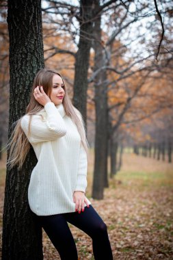Güz parkında poz veren güzel bir kadın. 