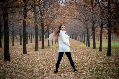 Güz parkında poz veren güzel bir kadın. 