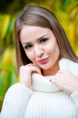 Açık havada beyaz kazak giyen güzel bir kadının portresi. 