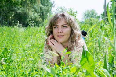 Yeşil çimlerle poz veren güzel bir kadın. 