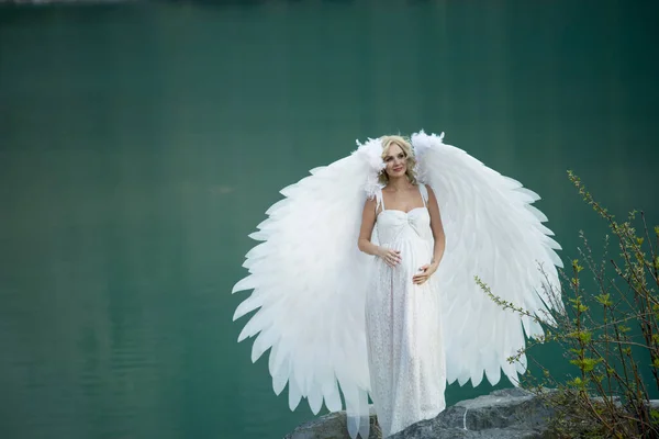beautiful bride with angel wings posing in nature