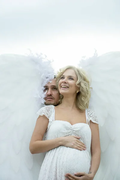美しい妊娠中の花嫁天使の翼は屋外で新郎とポーズ — ストック写真