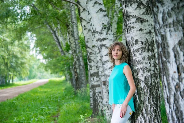 美丽的女人站在白桦树旁 — 图库照片