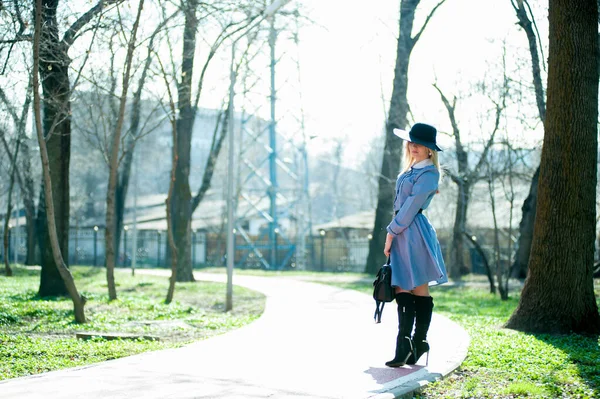 穿着蓝色衣服 高跟鞋 头戴礼帽的年轻貌美女子 背景衬托在院子里 — 图库照片