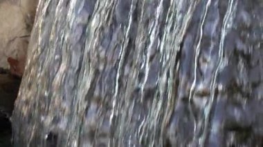 Arka plan için yavaş çekimde güzel küçük şelalenin yakın çekim görüntüleri