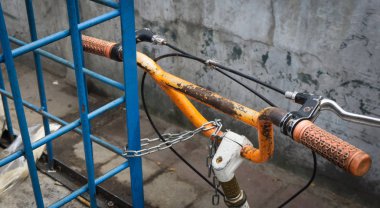 Jakarta Endonezya'da bir zincir fotoğraf kilitleyen bir park edilmiş Bisiklet turuncu gidon