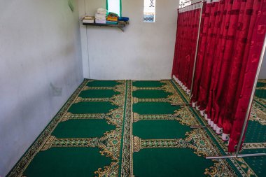 Yeşil halı ve kırmızı perde erkek ve kadın uzay arasında engeli ile boş bir Camii