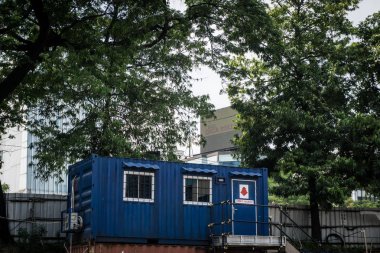 Mavi konteyner ev ofis veya ev olarak yeşil ağaç arka plan olarak