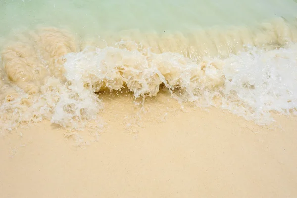 Foamy wave is incident on the yellow sand. The beach in a tropical Paradise, recreation, relaxation. Sea background
