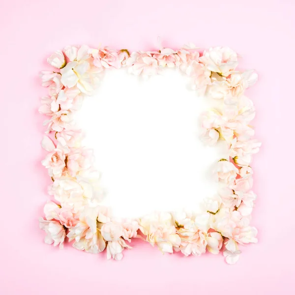 Frame of flowers on a pink background