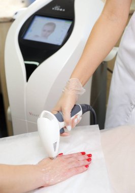 Belarus, Minsk-31 Ekim 2019: Viora V30.Kadın, tıbbi bir sanatoryum, cilt gençleştirme konseptinde yüz ve vücut ve ellere lazer ve ultrason tedavisi görüyor.