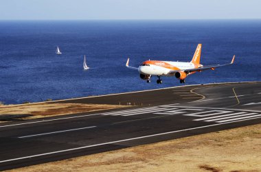 Havaalanı pistine giden kolay bir Jet Airbus uçağı. Ticari jet uçağı, Portekiz 'in Madeira, Funchal Havaalanı' na inmek için iniş takımlarını çalıştırdı. Atlantik Okyanusu. 12 Ağustos 2018.