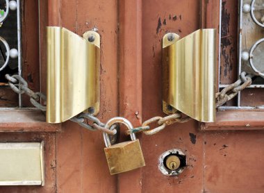 Eski bir kilit eski kapı kollarını tutar.