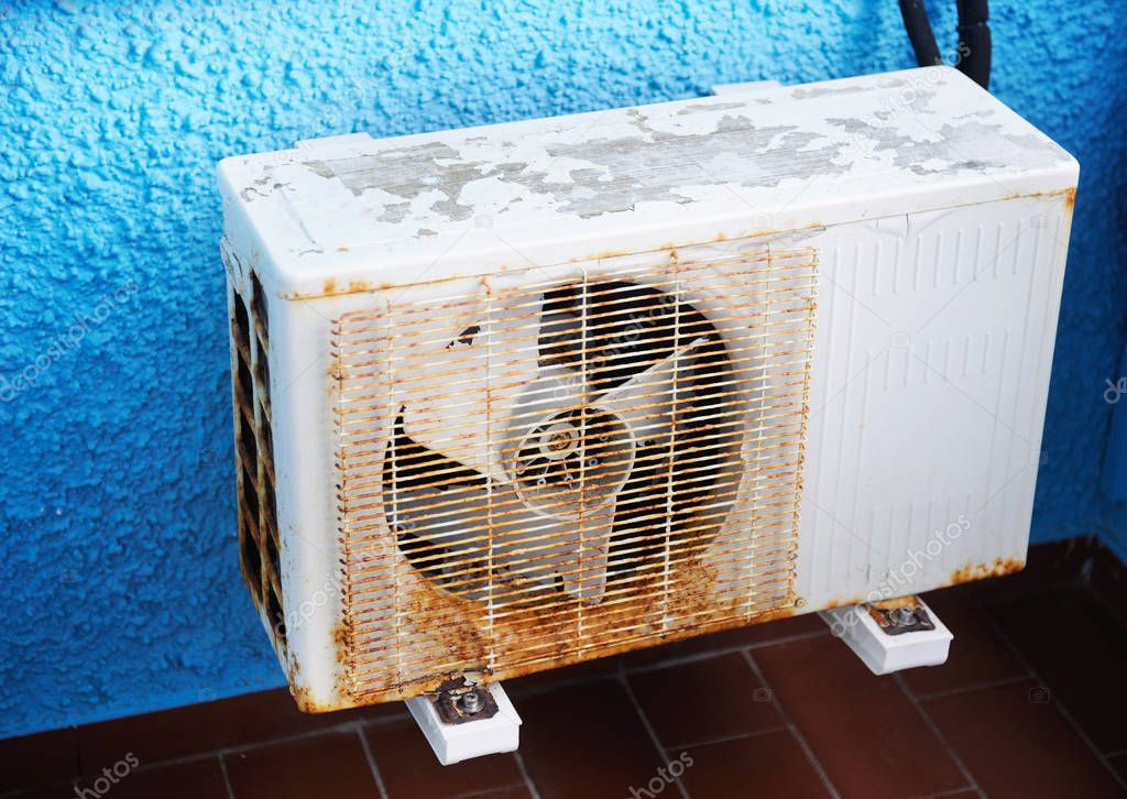 OLD AIR CONDITIONER ON THE BLUE WALL