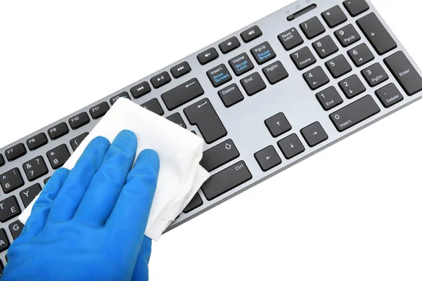 Worker's hand wipes dust and dirt on the keyboard. A maid or housewife takes care of the house. General, regular cleaning. The concept of a commercial cleaning company