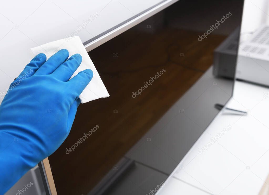 Worker's hand wipes dust and dirt on household appliances. A maid or housewife takes care of the house. General, regular cleaning. The concept of a commercial cleaning company