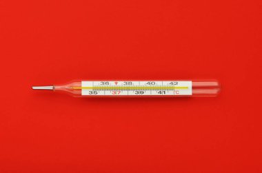 Kırmızı arka planda termometre. Grip salgını, koronavirüs. Sıcaklık 37.2 C.