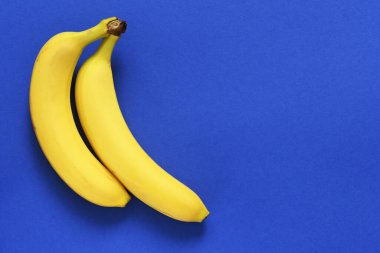 Mavi arka planda sarı muzlar, mesaj için yer var. Parlak renkler. Düz yatıyordu