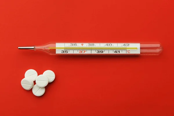 stock image Thermometer pills on a red background. Flu epidemic, coronavirus. Temperature 37.2 C.