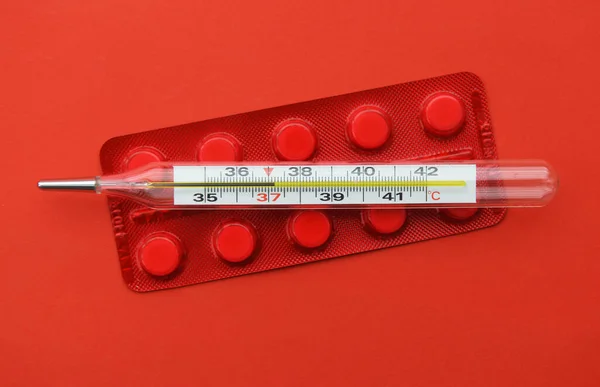 Kırmızı Arka Planda Termometre Hapları Grip Salgını Koronavirüs Sıcaklık — Stok fotoğraf