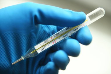 Grip salgını sırasında elinde termometre olan bir doktor. Grip salgını, koronavirüs. Sıcaklık 37.2 C.
