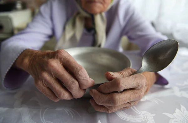 上からの眺め90歳の祖母の手には 空のアルミボウルとスプーン 貧困と貧困 古い世代の飢餓があります — ストック写真