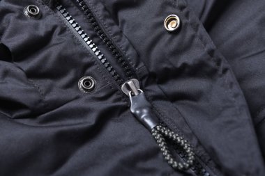 Siyah bir ceketin üzerindeki siyah fermuarın yakın çekimi. Fermuarlı kış ceketi, yakın plan..