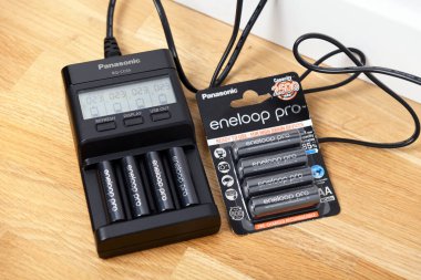 Warszawa, Polonya 4 Mart 2020: Panasonic Eneloop Pro şarj edilebilir nikel metal hidrit (Ni-MH) bataryaları. Parke katta şarj edici PANASONIC ENELOOP BQ CC65 LCD.