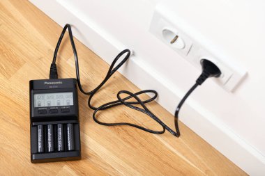 Warszawa, Polonya 4 Mart 2020: Panasonic Eneloop Pro şarj edilebilir nikel metal hidrit (Ni-MH) bataryaları. Parke katta şarj edici PANASONIC ENELOOP BQ CC65 LCD.