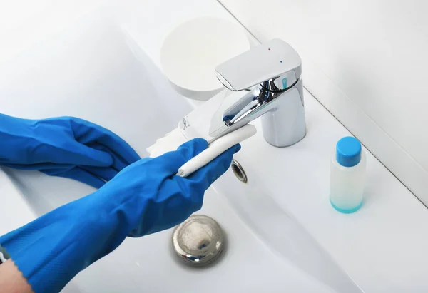 Lavabo ve musluğu deterjanla temizleme. Coronavirüs önleme, koronavirüs yaymayı durdurmak için hijyen. Ev hanımı ya da bir hizmetçi evle ilgilenir. Genel ya da düzenli temizlik