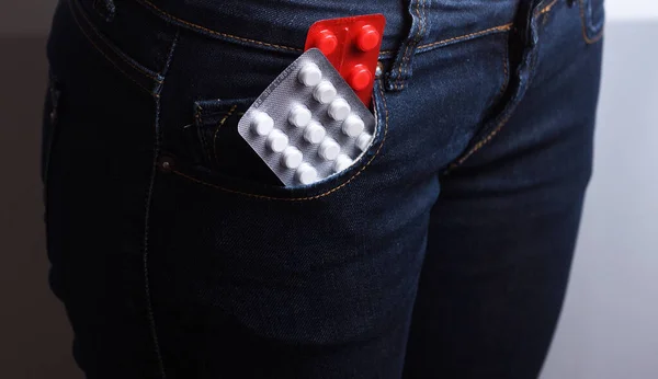 Pack of pills in the fly of blue jeans on a white background. Sexual diseases. Sexually transmitted diseases.Birth control in jeans pocket, closeup. Safe sex concept. — Stock Image Pack Pills Fly Blue Jeans White Background Sexual Diseases Sexually Royalty Free Stock Photos